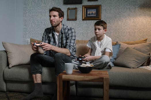 A father and son enjoying a bonding moment playing video games together in a cozy living room.