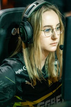 Young female esports player intensely focused during a gaming match, wearing headphones.